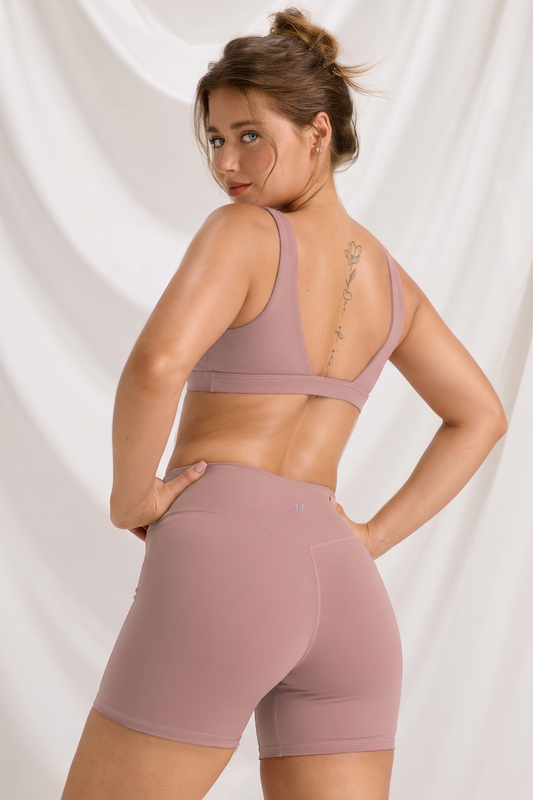 Rear view of the dusty rose sports bra and high-waisted shorts workout set