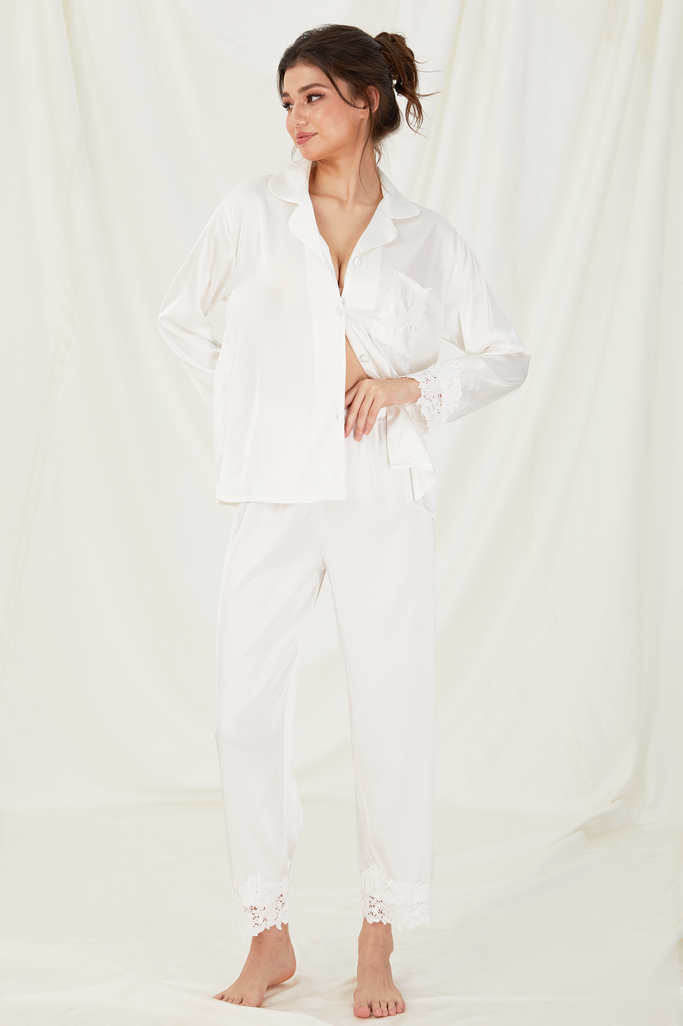 Woman wearing a white satin outfit against a white background