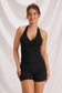 Front view of black crossover halter workout top and matching fitted shorts