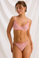 Front detail of pink floral lace lingerie with sheer bra cups, ruffled trim and adjustable thong side straps