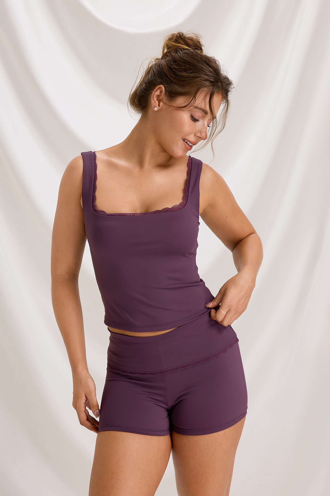 Front view of a plum lace-trim workout tank and matching fitted shorts on a model