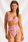 Front view of pink sheer lingerie set with floral embroidered bra, thong panty and garter belt