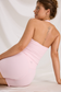 Seated rear view of the pink halter workout top and matching high-waisted shorts, showing the open back