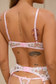 Back view of pink floral lingerie set showing adjustable bra straps and back of garter belt.