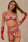 In classic red and white, this holiday lingerie set adds an extra spark to the celebration. With intricate floral embroidery in scarlet and white, this three-piece set wraps your curves in passion and elegance. The bra has a beautiful neckline with bold red satin bows and sparkly charms. The unique garter belt features a heart shaped charm in the from, its strappy design is sexy and flattering to the waist. From the sexy leg straps to the criss cross thong, every detail invites a closer look. Bring your lov