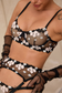 close-up of embroidered black bra and garter belt with floral detailing
