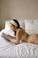 lifestyle photo of yellow lace lingerie set worn in bed with garter belt and thong